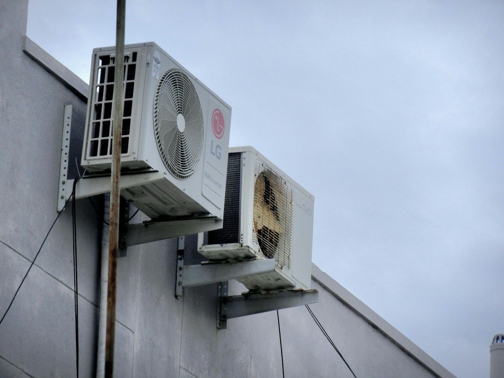 a wall mounted air conditioner mounted on the side of a building  for Professional Heating & HVAC System Services in Lynn Haven, FL