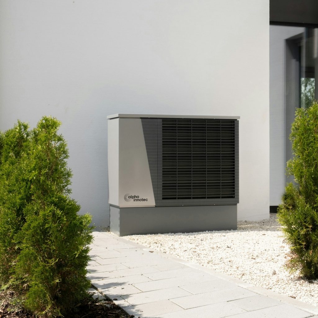 A high-efficiency condenser unit fitted neatly against a home's exterior wall — the dependable outcome of trusted Heating and HVAC System Services near me.